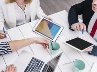 crop-businesspeople-with-gadgets-desk